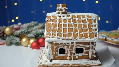 The process of creating and decorating a gingerbread Christmas house. A woman Stock Footage 257796501