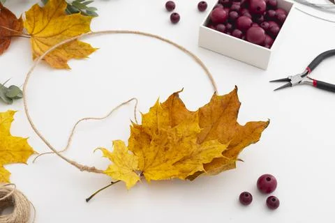 The process of creating an autumn decorative wreath made of dry yellow leaves Stock Photos