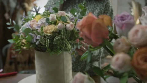 Process of creating beautiful composition of fresh flowers in floral workshop Stock Footage 153106883