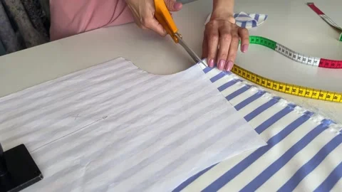 The process of creating clothes in the atelier. Tailor carefully cutting blue Video stock 312565699