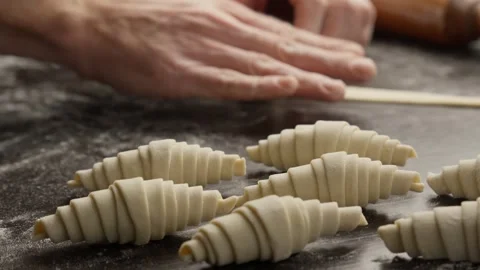 Process of creating croissants in bakery. Male hands twisting dough with hands Video stock 299549283