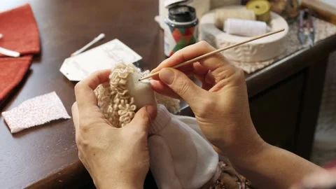 Process of creating a doll: master draws a toy eyes. Thin brush for drawing: the Stock Footage 153589942