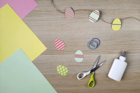 Process of creating Easter garland with decorative eggs. Flat lay. Stockfoto's