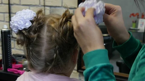 Process of creating a hairstyle from braiding braids for young girl in Stock Footage 142667042