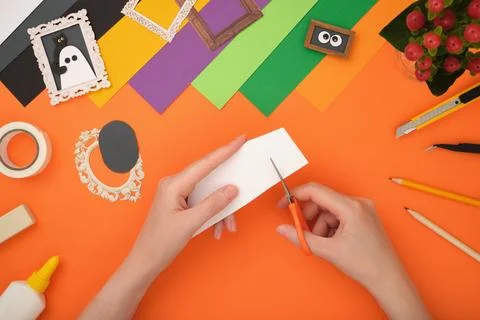 The process of creating a Halloween craft. Cut out the silhouette of a ghost  Stock Photos