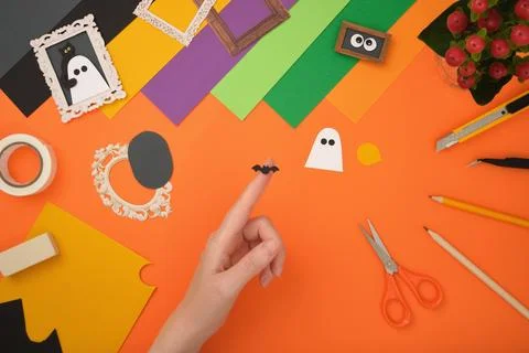 The process of creating a Halloween craft. Cut out the silhouette of a bat fr Stock Photos