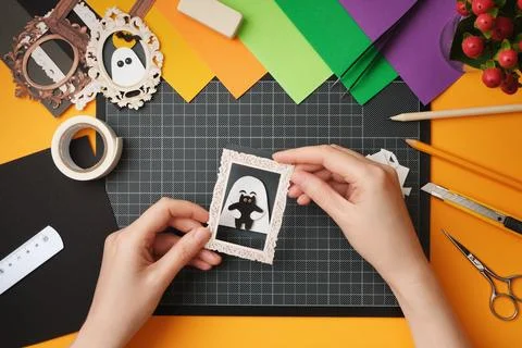 The process of creating a Halloween craft. Stick the ghost onto the backgroun Stock Photos