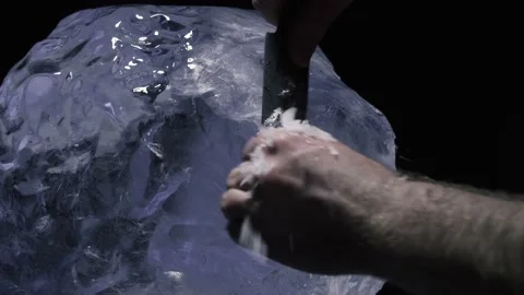 Process of creating an ice sculpture, artist is working with a knife, carving 4k Stock Footage 153440439