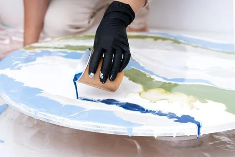 The process of creating a painting using fluid art technique. Stock Photos
