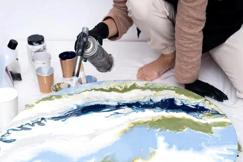 The process of creating a painting using fluid art technique. Stock Photos