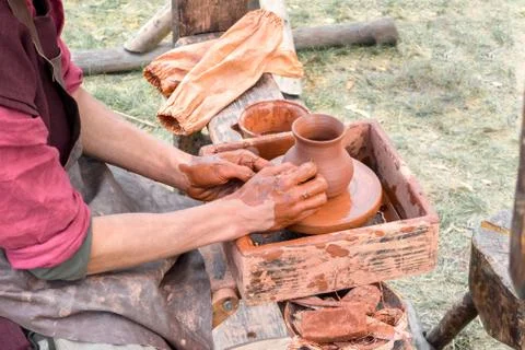 Process of creating relief on clay pot with textured comb. Spin on circle. On Stock Photos