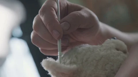 Process of creating a teddy bear: master paints the ears with a toy Stock Footage 75487037