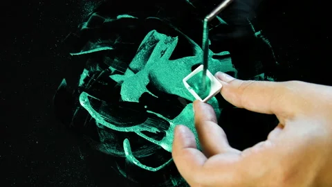 Process of creating watercolor using palette knife and pigment, black background Stock Footage 138806955