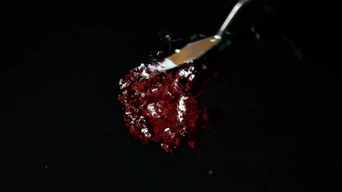 Process of creating watercolor using palette knife and pigment, black background Stock Footage 138808100