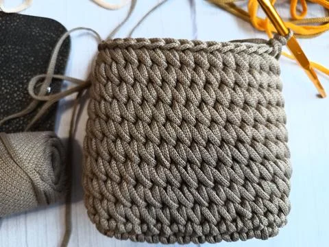 The process of crocheting a handbag made of cord and leather accessories Stock Photos