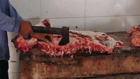 The process of cutting beef ribs using the traditional tool an axe. Video stock 277721386