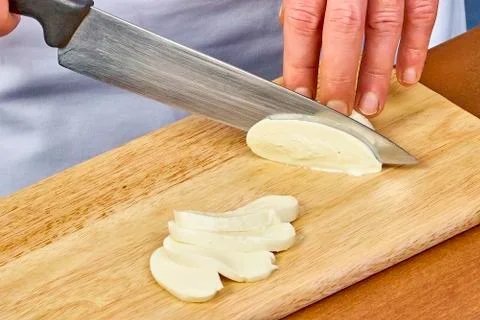 The process of cutting the cheese mozzarella on a cutting board closeup Stock Photos