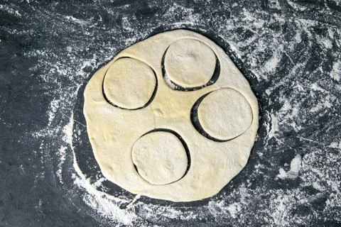 The process of cutting circle from the dough on a dark background. Top views, Fotos Stock