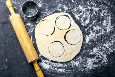 The process of cutting circle from the dough on a dark background. Top views, Stock Photos