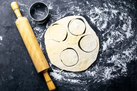 The process of cutting circle from the dough on a dark background. Top views, Fotos Stock
