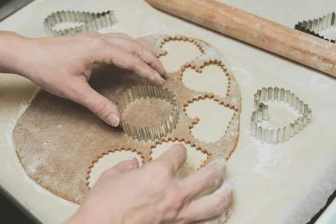 Process of cutting cookies by cookie cutters. Woman making by hands forms for Stock Photos