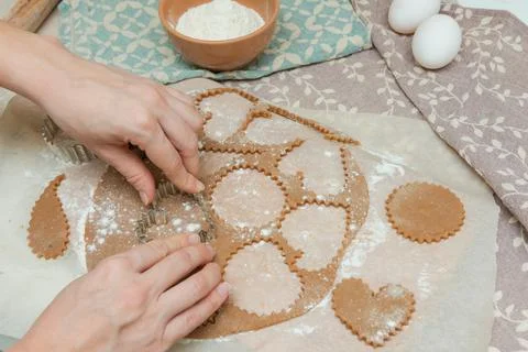 Process of cutting cookies by cookie cutters. Woman making by hands forms for Stock Photos