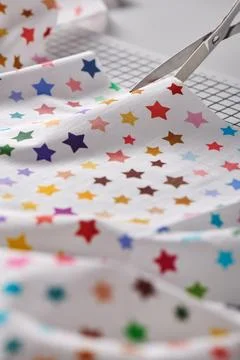 Process cutting fabric with a pattern of colorful stars by scissors on craf.. Stock-Fotos
