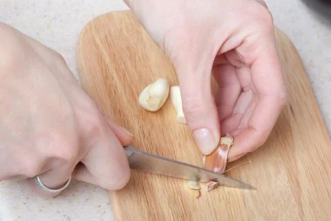 The process of cutting the garlic on a cutting board closeup Stock Photos