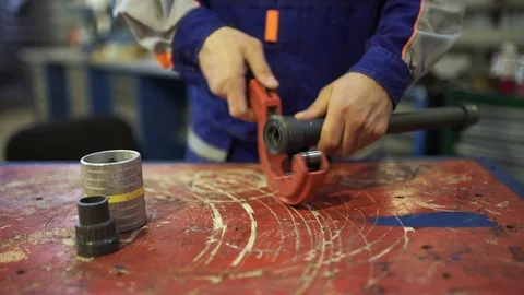 The process of cutting a piece of pipe PVC using a pipe cutter Stock Footage 92864213