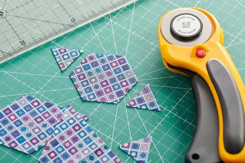 The process of cutting pieces of fabric in the shape of hexagons to create .. Stock Photos
