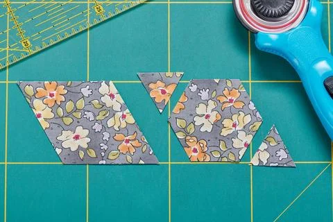 The process of cutting pieces of fabric in the shape of hexagons to create .. 库存照片