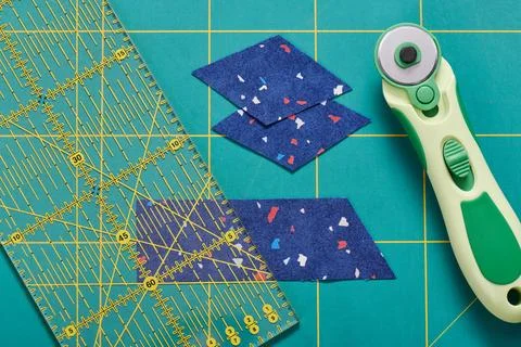 The process of cutting pieces of fabric in the shape of diamonds to create .. 스톡 사진