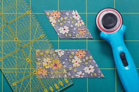 The process of cutting pieces of fabric in the shape of diamonds to create .. 库存照片