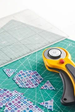 The process of cutting pieces of fabric in the shape of hexagons to create .. Stock Photos