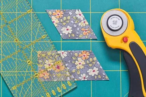 The process of cutting pieces of fabric in the shape of diamonds to create .. Stock-Fotos