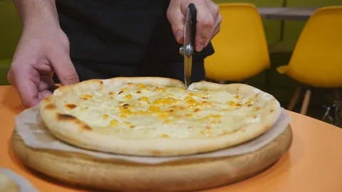 The process of cutting pizza on a wooden background Stock Footage 111566761