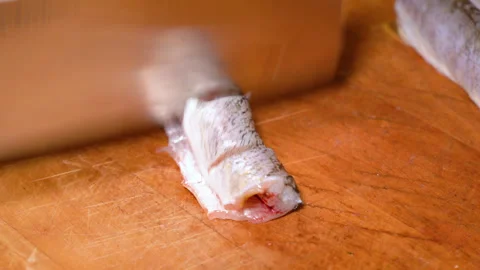 The process of cutting a small pike on a wooden board Stockbeeldmateriaal 251005234
