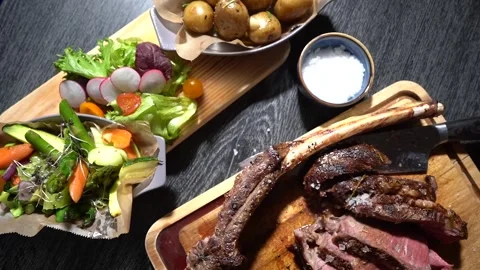 Process of cutting the steak with a large kitchen knife on a cutting board. Stock Footage 261461842