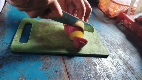The process of cutting sweet potatoes (Ipomoea batatas) on a cutting board Stock Footage 213205494