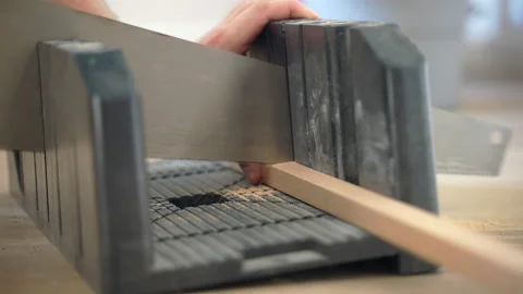 Process of cutting think raw wooden plank with hand saw forming sawdust on the Video stock 228913256