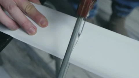 Process of cutting white plastic skirting Board with hacksaw. Stock Footage 143707175