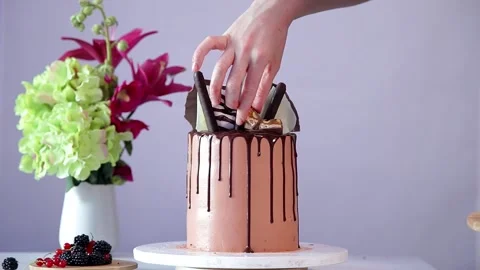 Process of decorating birthday cake with pieces of chocolate. Video stock 150332268