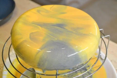 Process of decorating cake with mirror glaze. The girl creates a drawing of m Stock Photos