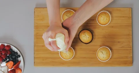 Process of decorating cupcakes with a cream, top view Stock Footage 129327773