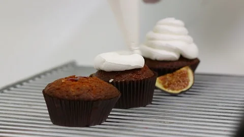 The process of decorating cupcakes with cream using confectionery bag. Stock Footage 126709737