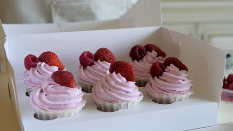 Process of decorating cupcakes with fresh strawberries and raspberries Stock Footage 142964084