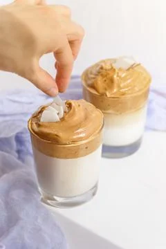 Process of decorating dalgona coffee with hand on white background in morning Stock Photos