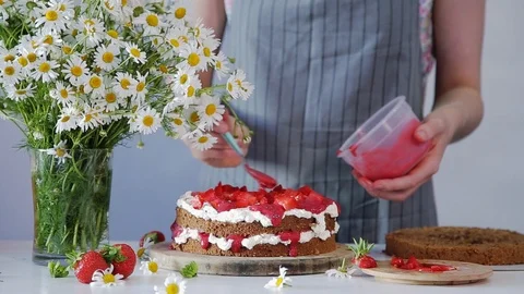 The process of decorating filling of the cake with pink jam Stock Footage 102932032