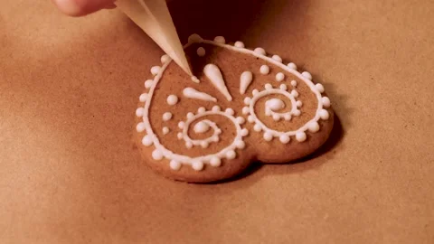 The process of decorating with sugar glaze gingerbread in the form of a heart Stock Footage 167333762