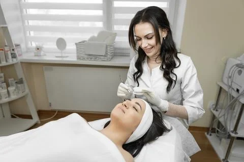 The process of deep cleansing of facial skin is presented, during which a young Stock Photos